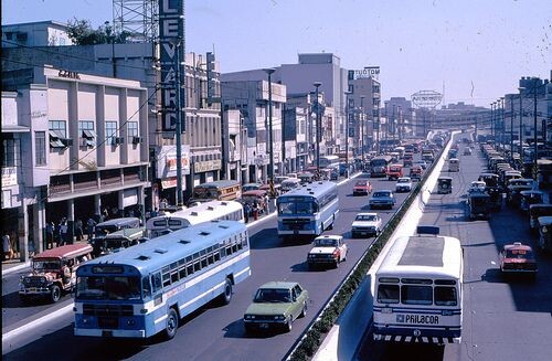 a picture of buses and cars running along a wide city road