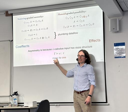 Dominic Orchard, gesturing at a slide in a presentation about graded modalities. The key point is that there is a significant difference between box-type modalities (which can be seen to manipulate coeffects) and diamond-type modalities (which manipulate effects), in parallel with the left/right asymmetry in the term-assignment setting of the λ calculus.
