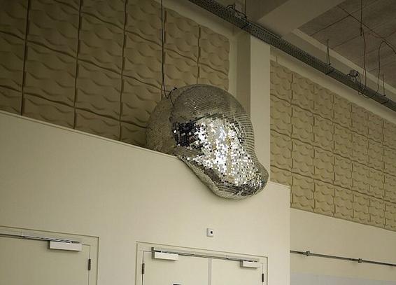 a big disco ball on a ledge above a doorway that appears to be melting.