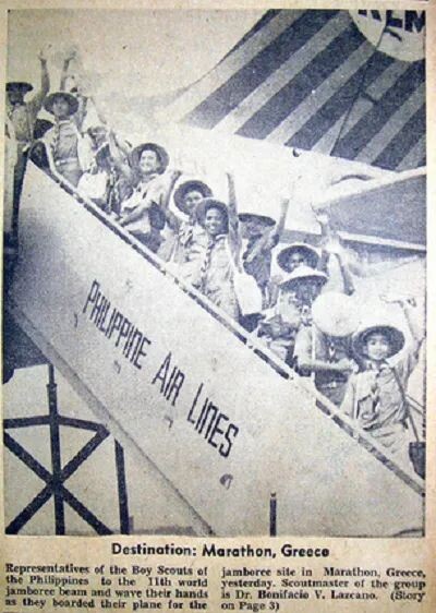 a group of young boys posing for a photo while boarding a plane and waving
