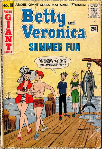 Betty Cooper, a blonde girl in a sailor hat wearing green clam diggers pants and a green and black top holds a fishing pole and is standing next to a huge fish she caught that is almost the size of her. To her right is Jughead Jones in his usual crown hat and black pants with red socks and a blue shirt. They’re watching Veronica Lodge and Archie Andrews, a red-headed boy in orange shorts walking in front of them arm-in-arm. Veronica, a brunette girl is wearing a black and white-striped one piece bathing suit with a red short-sleeved jacket over it with an enormous sun hat with black and white stripes that match her suit and red shoes that match her jacket. As Betty looks on Jughead says, “Offhand, I’d say Veronica caught the BIGGER fish!”