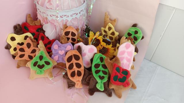 A bunch of handmade plushie kologs in different color combinations, from the Zelda breath of the wild videogame