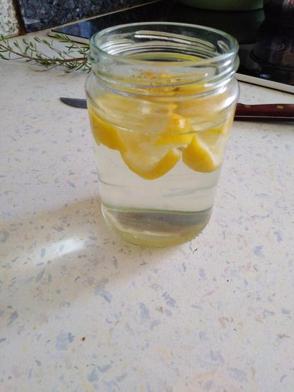 Zitronenschale kleingeschnitten mit heißem Wasser in Marmeladenglas