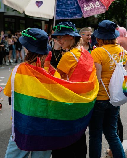 Zwei Frauen in eine Pride-Fahne gehüllt