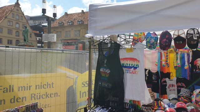 Bild zeigt einen Verkaufsstand auf dem CSD mit Regenbogenshirts.