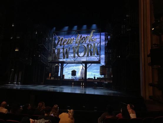 Stage showing a NYC rooftop with a large New York, New York billboard and the Empire State Building in the far distance