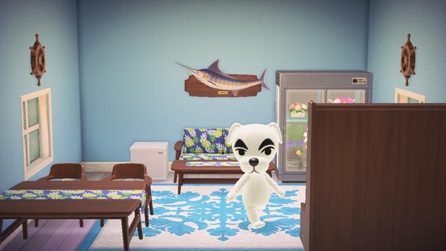 Animal Crossing: New Horizons screenshot. Happy Home Paradise setup of K.K. The room has light blue wallpaper and white birch flooring with a blue Hawaiian print rug. The room is filled with Nordic furniture. K.K. is seen walking in the middle of the room looking around.