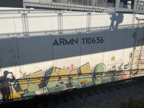 ICH with a skull on a white box car. A shadow from a ramp goes across the middle of the car, above the piece