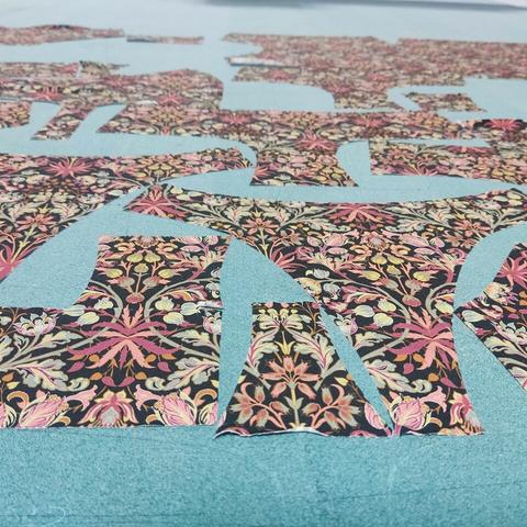 Zugeschnittene Stoffstücke für Unterwäsche. Zu erkennen sind Teile für Slips und Hipster. Der Stoff nennt sich "Mandala" und ist floral gemustert.