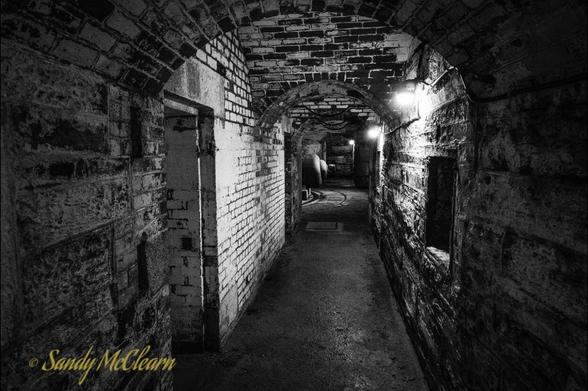 Underground passageway with side passageways and the back of an RML gun in the background.