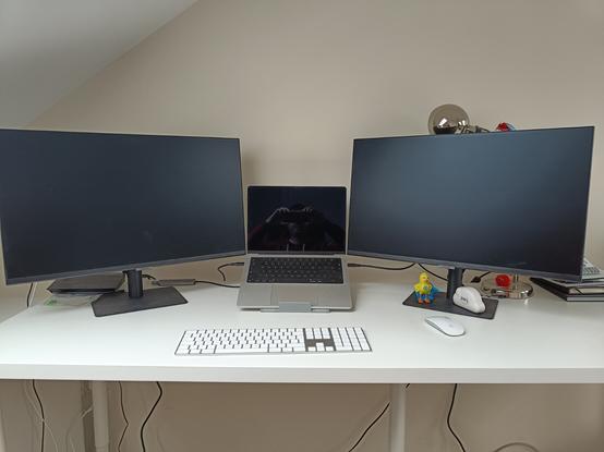 White Desk showing a MacBook Pro, two monitors and a wireless Apple keyboard and mouse