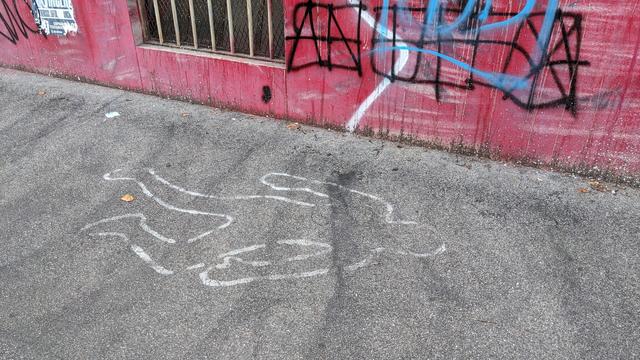 Desegno de la konturoj de homo per blankaj linioj en la strato