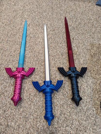 Three master swords in different colors placed out on the floor.