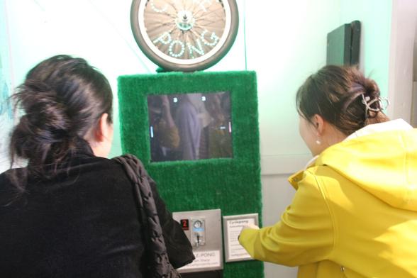 Rear view of two people concentrating intently on a game of "cycle pong". The score is currently 3-3.