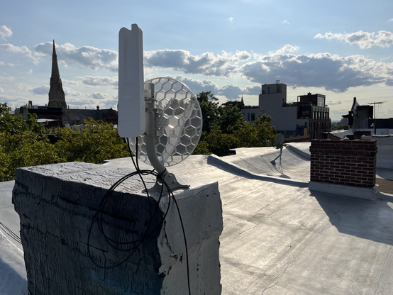 Glamor shot of my NYC Mesh antenna setup. The antennas are mounted on top of a chimney. One is a directional dish, the other is an omnidirectional node.