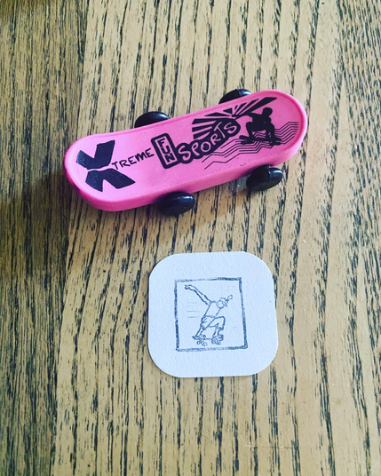 Mini grabado con skater junto a un juguete de goma con forma de skate