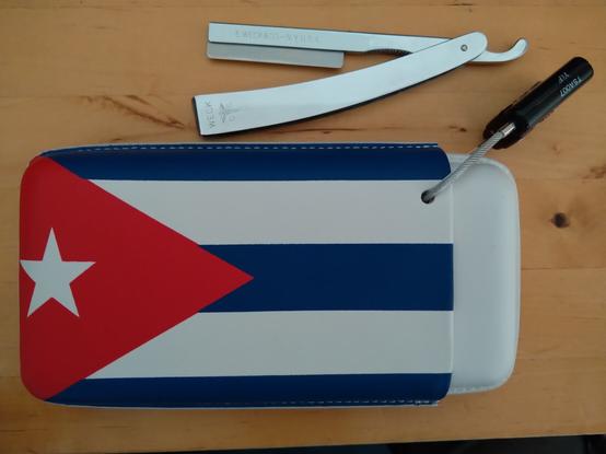 A leather cigar box with a hole drilled through so it can be locked shut with a standard TSA cable lock. Shown in locked configuration