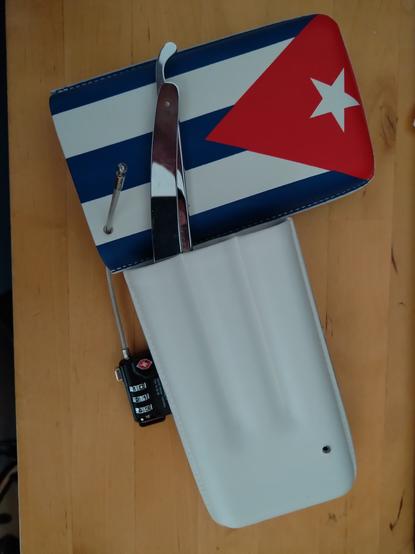 A leather cigar box with a hole drilled through so it can be locked shut with a standard TSA cable lock. Shown in locked configuration