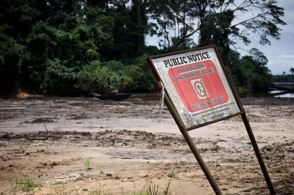 A warning sign infront a polluted Niger delta some 20 years later.