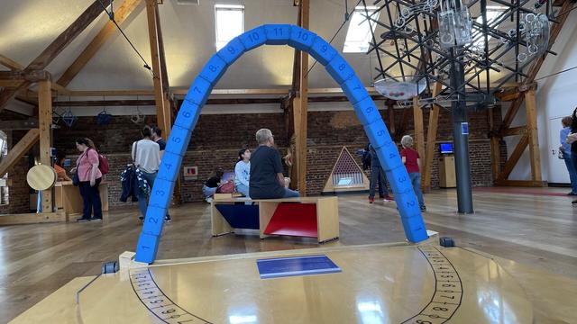 Foam catenary arch in room full of people and exhibits.