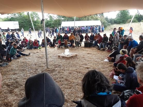 Assemblée en cercle sous un chapiteau