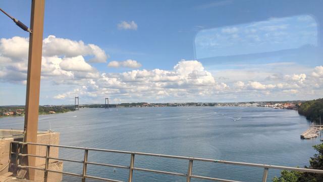 View from a train onto the baltic sea below the bridge to Funen. There are many small boats on the water surface.