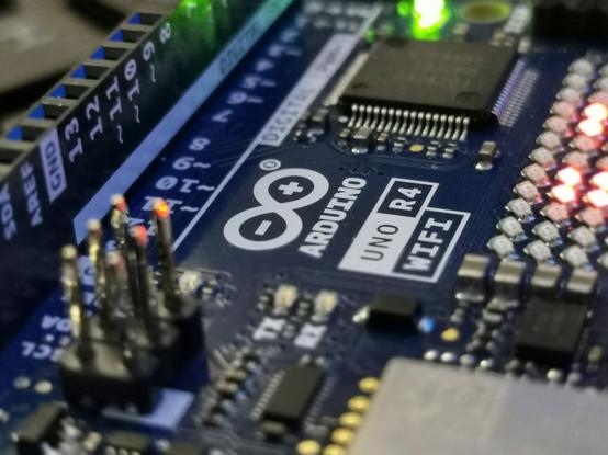Eine Nahaufnahme eines Microcontrollers mit der Aufschrift Arduino Uno R4 WiFi.
