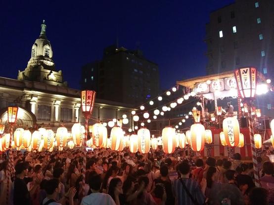 Photo of the Buddhist temple Tsukiji Hongan-ji at night. Laterns and festivities to mark the beginning of the Summer Festival.