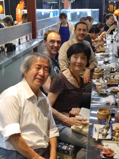Photo of four scientist at a Sashimi bar in the Tsukiji district of Tokyo.