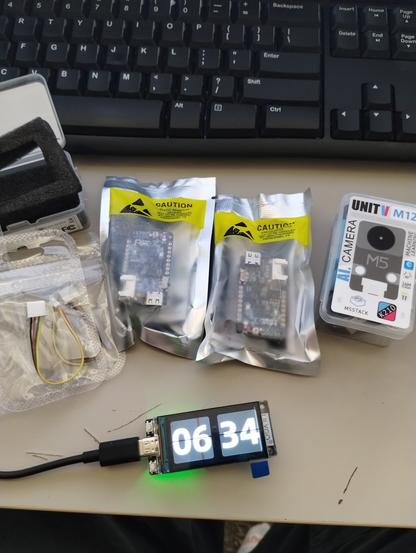 Some qwiic to grove cables, Lilygo T-IO Plus boards, M5Stack Unit V M12 AI camera, and Lilygo T-Display S3 board powered up.  everything else is new in retail packaging.