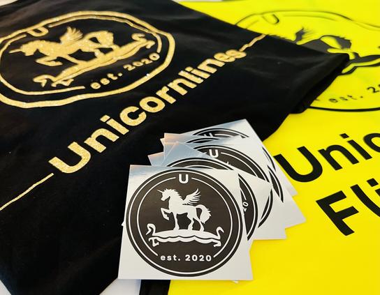 Unicornlines Merch - Stickers in black and silver, a black t-shirt with golden print and a high viz west for the flight crew with a black print.