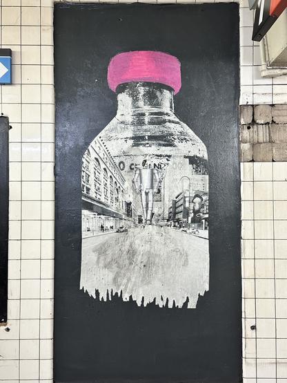 a wheatpasted picture of an insulin vial with a pink lid on a black panel in a nyc subway station. inside the vial is the tin man walking down a city street. the bottom edge of the vial is shredded