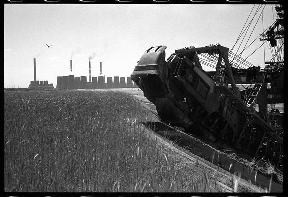 Schwarzweißfotografie von Jürgen Matschie. Eimerkettenbagger und Kraftwerk Boxberg, aus der Serie Bergbau – Im Tagebau Nochten.