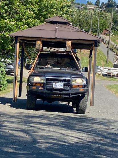 Reid, in his Toyota truck, hauling a fully intact gazebo frame, atop.