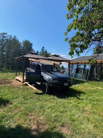 Reid, in his Toyota truck, loading a fully intact gazebo frame onto top of truck.