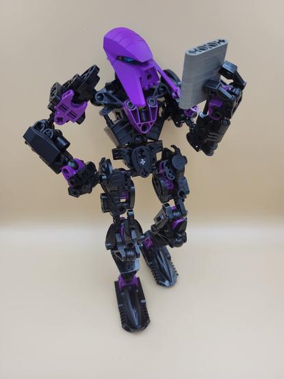 The same creation, now leaning back against a wall and reading from a makeshift stone tablet (also constructed from Lego/Bionicle pieces).
