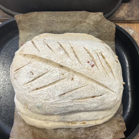 Closeup from above of the dough in the uncovered oven pan; the leaf effect scoring on top looks quite nice.