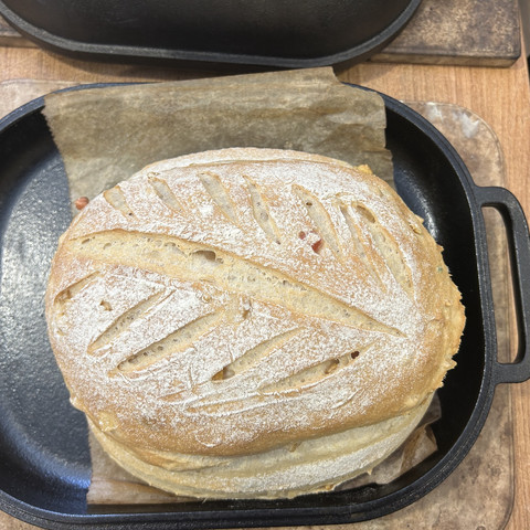 Closeup from above of the bread (still in the pan) after 20 minutes of baking with the lid on. It has puffed up very nicely, has coloured a bit and is coming along nicely.