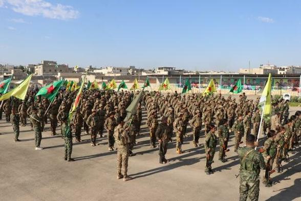 The picture shows YPJ and YPG fighters in a military ceremony
