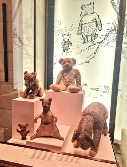 A display of old and much-loved stuffed animals
 There's a bear (Pooh), a tiger (Tigger), a donkey (Eeyore), a kangaroo (Kanga), and a very small pig (Piglet). They look very much like the characters in the famous story.