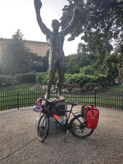 A loaded touring bike in front of the Rocky Statue.