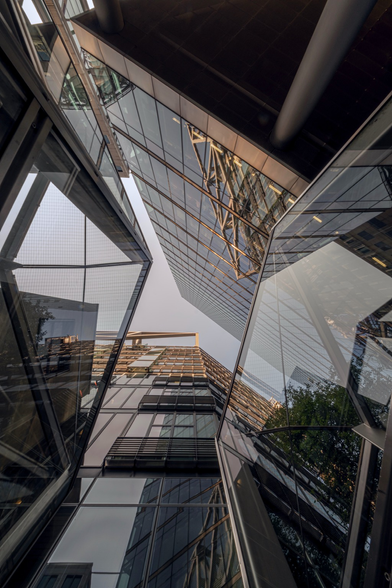Der Blick nach oben zwischen zwei Häusern mit viel Glas