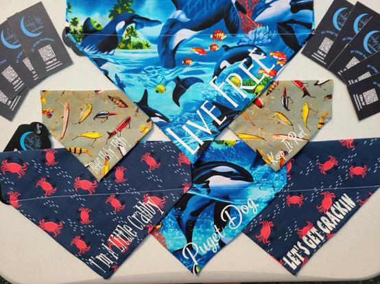 Orca pet bandanas that say "Live Free" and "Puget Dog", our crab bandanas that say "I'm A Little Crabby" and "Let's Get Crackin", and our fishing lure bandanas that say "Keep It Reel" and Beer Fishy Fishy"