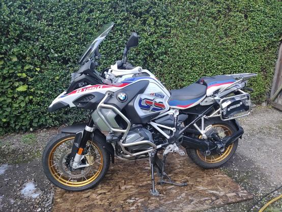 A large white BMW motorcycle, surrounded by damp ground. It's fairly clean, but don't look too close.