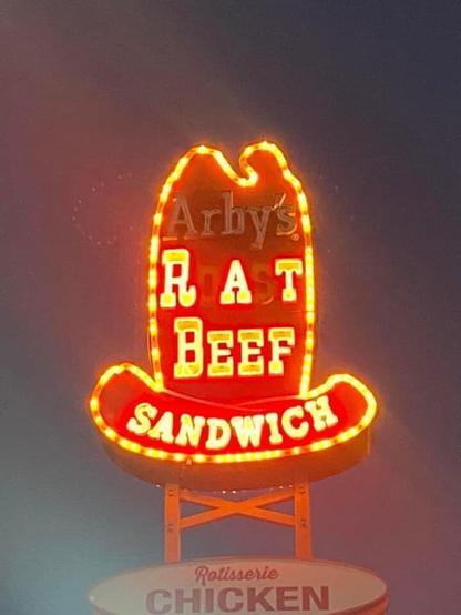 An old "Arby's Roast Beef Sandwich" sign, with letters burned out so it says "Rat Beef Sandwich"