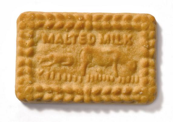 Image of malted milk biscuit. The biscuit is embossed with an image of cows grazing, and the words "Malted Milk".