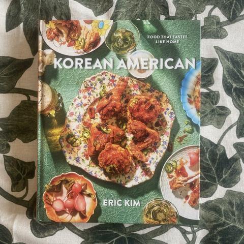 Kokeboken Korean American av Eric Kim. Boken ligger på en bladmønstret duk.
