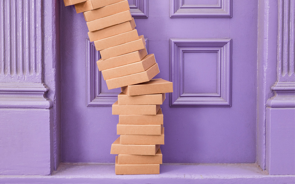 an askew stack of cardboard boxes in front of a purple building