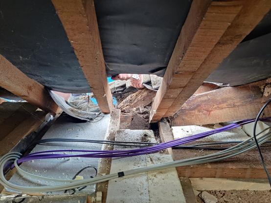 Inside the roof looking out through a hole in the roofing felt evidence of the rotten timbers can be seen in the centre at the back of the roof.