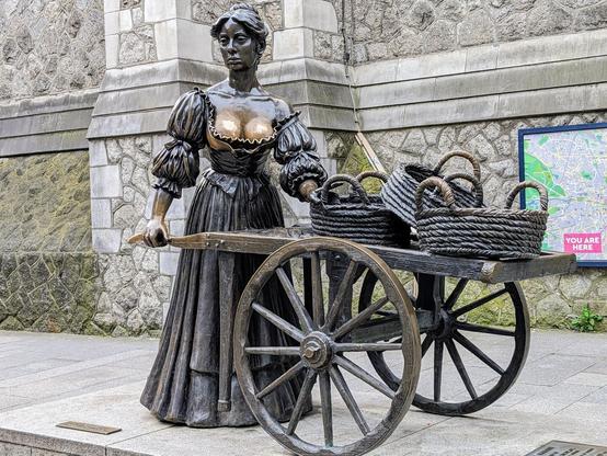 A statue of Molly Malone (from the popular Irish song) pushing a hand cart.